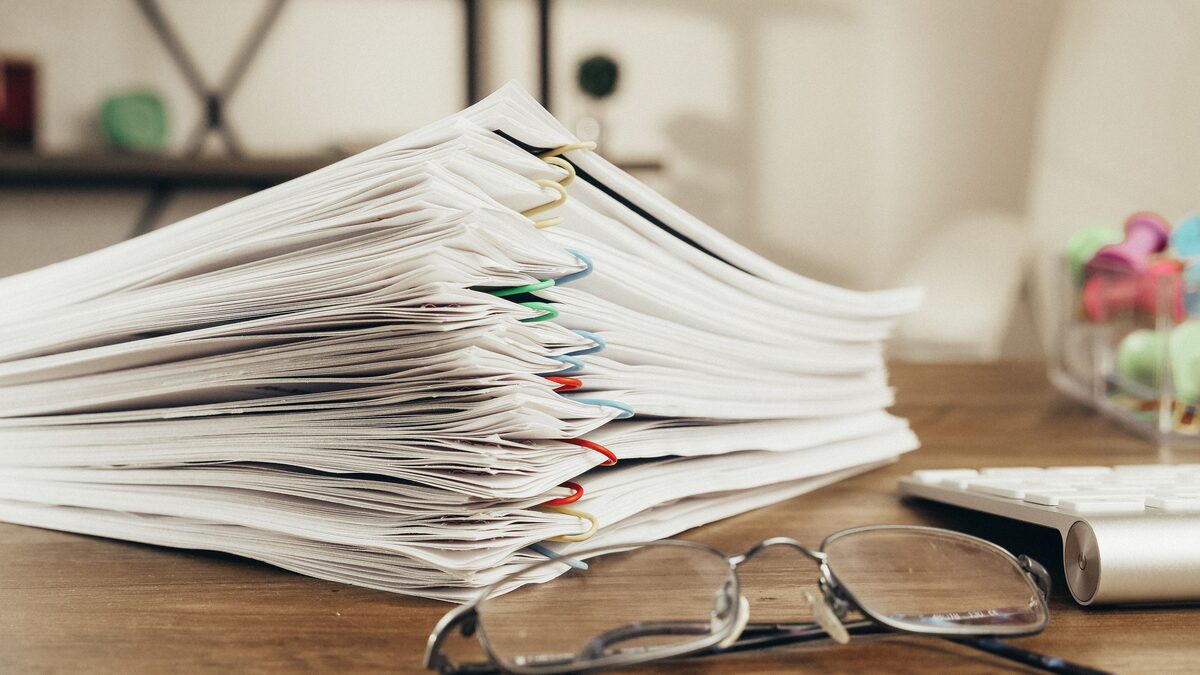 Before: a tall stack of case papers held with coloured clips, waiting on a desk